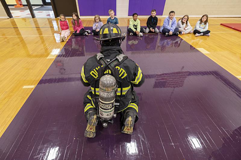Dixon City firefighter Tyler Hansler speaks to students Thursday, Oct. 12, 2023 during a demonstration for Fire Prevention Week at Jefferson School. It’s important for kids to recognize and not be scared when seeing a firefighter in all their gear so they can be helped in an emergency.