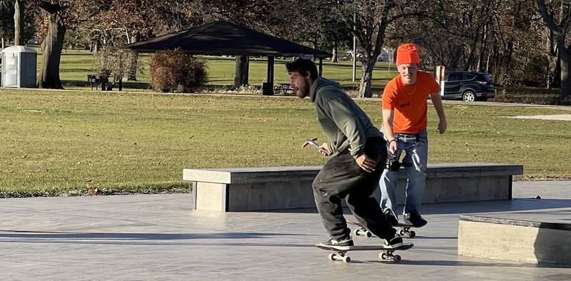 Nico Positano, 29, completed a line, with Wray Martin filming, at the Sycamore skatespot on Nov. 15, 2025, while holding a freshly grilled hot dog in tongs.