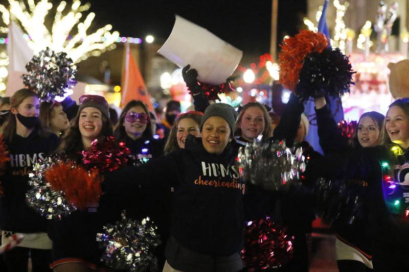 Members of the Hannah Beardsley Middle School cheerleading team entertain as they pass by during the annual Festival of Lights Parade on Friday, Nov. 26, 2021, in downtown Crystal Lake.