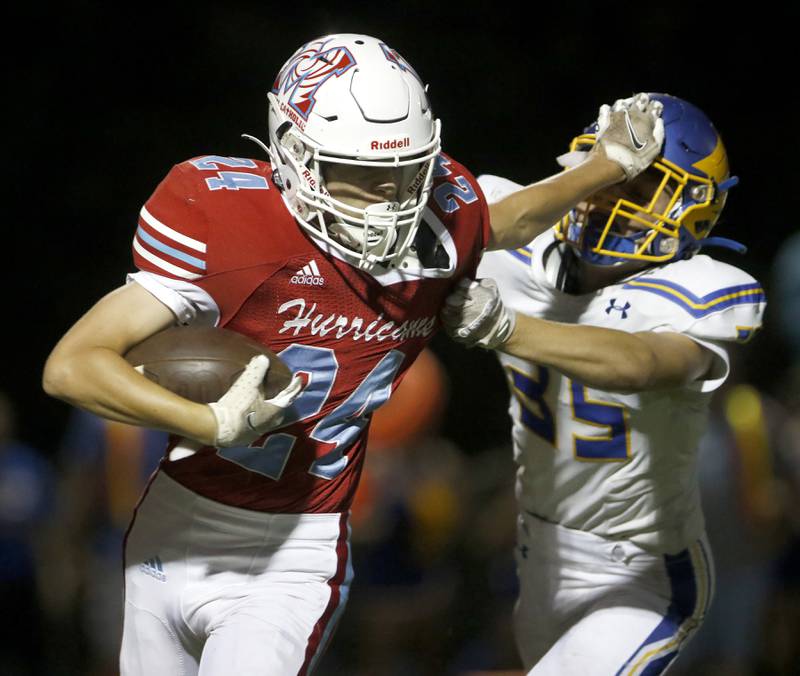 Marian Central's Anthony Brennan stiff arms Johnsburg's Nicholas Leight Jr.,  as he runs with the ball during a non-conference football game Friday, Sept. 2, 2022, between Marian Central and Johnsburg at Marian Central High School.