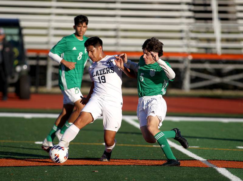 Addison Trail’s Joel Alvarez Cruz (19) gets the ball away from York’s Michael Greco (5) during a Class 3A St. Charles East Sectional semifinal game on Wednesday, Oct. 26, 2022.