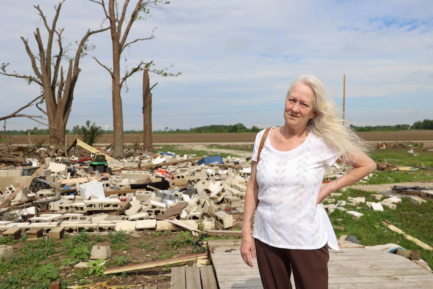 Sue Antonelli stands on the deck that once led from her former Sandbar Road home to the Kankakee River on May 19, 2026, following the March 10 tornado that leveled her Aroma Township property. Antonelli said she's unsure if she'll rebuild or return to the property that once hosted many joyful moments.
