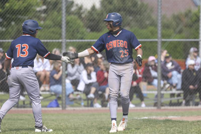 Oswego's Kam Jenkins (25) is greeted by Bryson Norwood (13) after scoring a run during Class 4A Plainfield North Regional final baseball game between Oswego at Plainfield North. Saturday, May 31, 2025 in Plainfield.