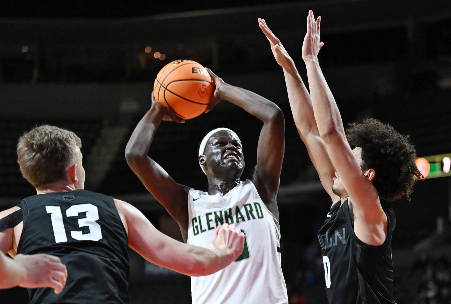 Glenbard West's Josh Abushanab makes a strong move to the basket between Evanston's George Richardson, left, and Jayden Rodriguez during the Class 4A boys supersectional at NOW Arena on Monday, March 10, 2025 in Hoffman Estates.