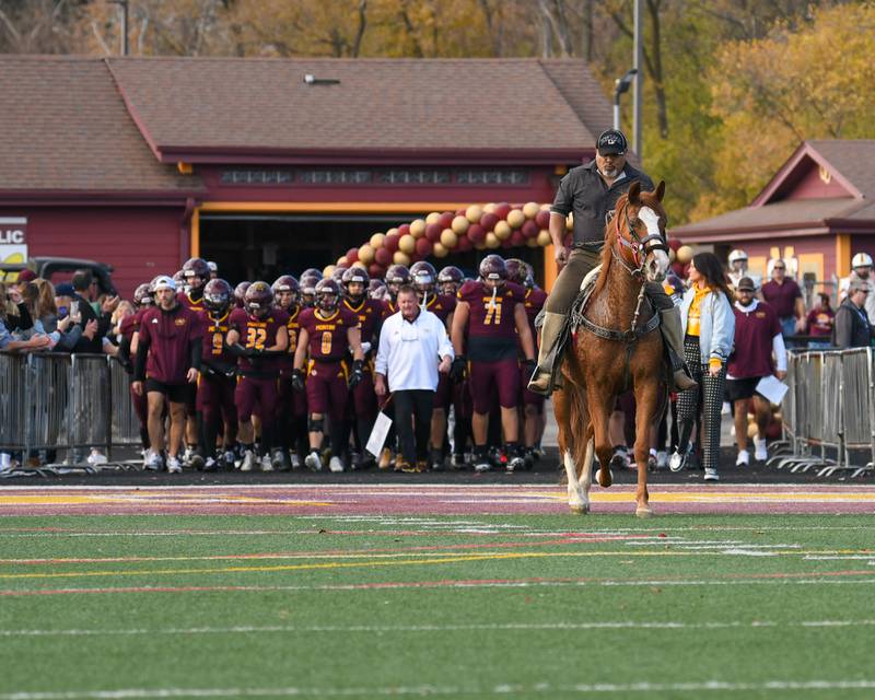 Montini Catholic High School is lead to the field by a horse before the start of the 4A quarterfinals game on Saturday Nov. 15, 2025; while taking on Coal City held at Montini Catholic High School.