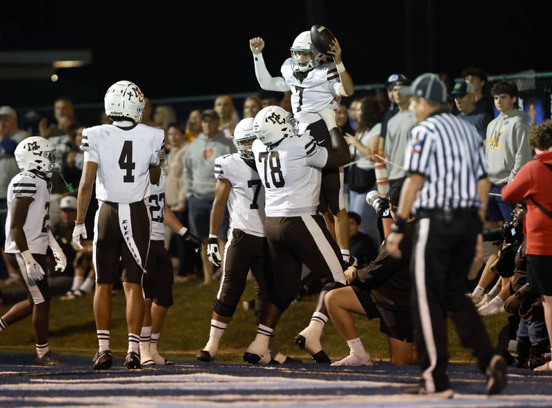 Mt. Carmel's Emmett Dowling (7) is lifted in celebration by Claude Mpouma (78) after scoring a touchdown during the varsity football game between Mt. Carmel high school and Nazareth Academy on Friday, Sept. 12, 2025 in La Grange Park, IL.