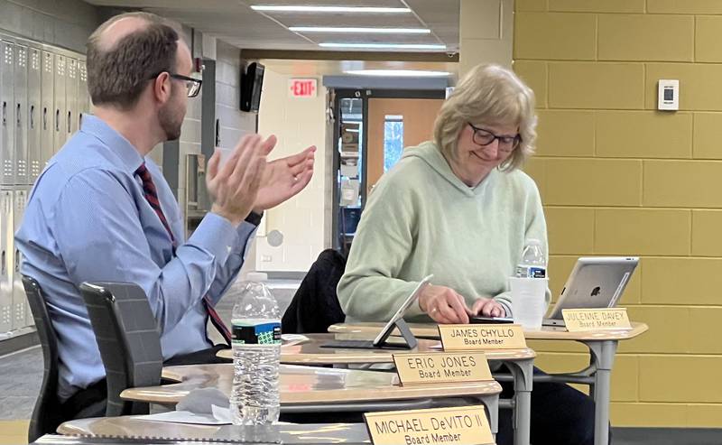 Sycamore Community School District 427 Board of Education member James Chyllo claps as board member Julenne Davey smiles and looks down at a plague awarded to her for her service to the board. Davey, along with board members Steve Nelson and Kris Wrenn, gave their fair wells on April 25, 2023, during their last meeting as members of the Board of Education.