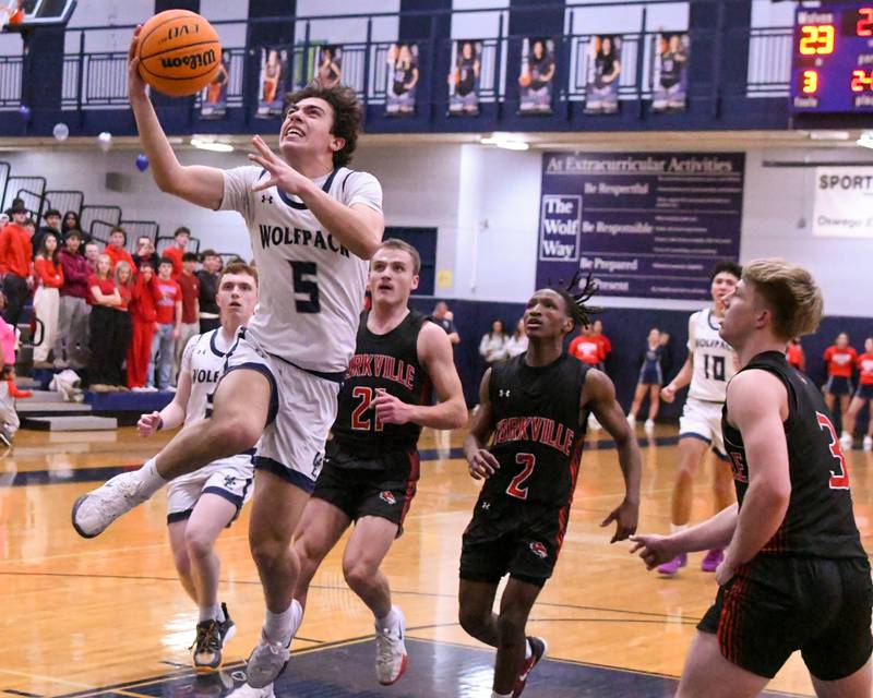Oswego East's Josh Lopez (5) makes a basket during the game on Friday Feb. 14, 2025, while being defended by Yorkville defenders held at Oswego East High School.