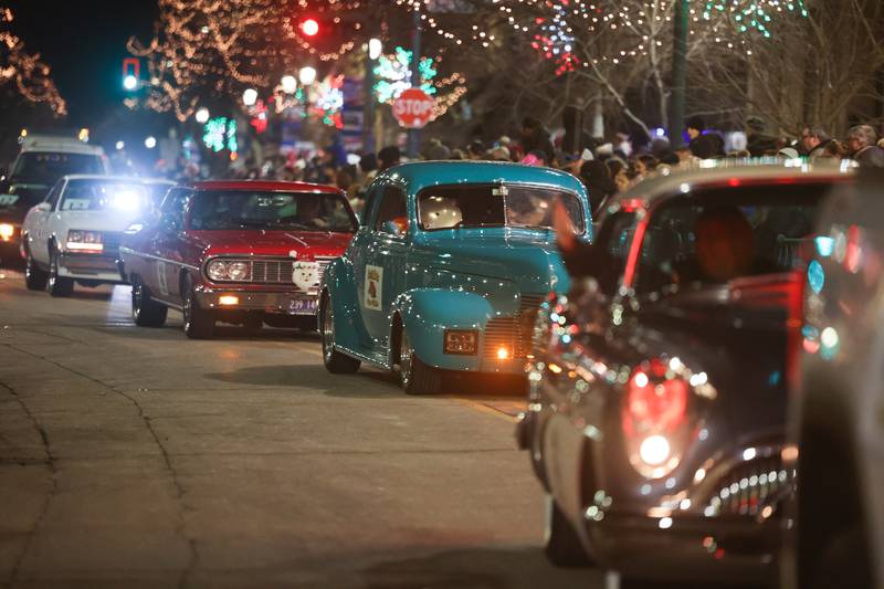 Vintage cars drives along Chicago Street at the Light Up the Holidays Festival and Parade in downtown Joliet.