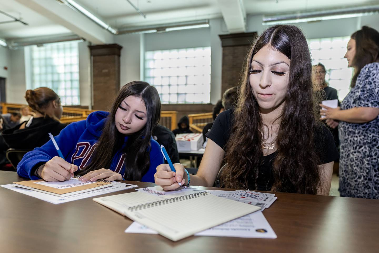 Daisy Miramontes and Hanna Stapinski write positive messages to include in the book packs during the Chick-fil-A Leader Academy at Lincoln School on Sept. 9, 2025.