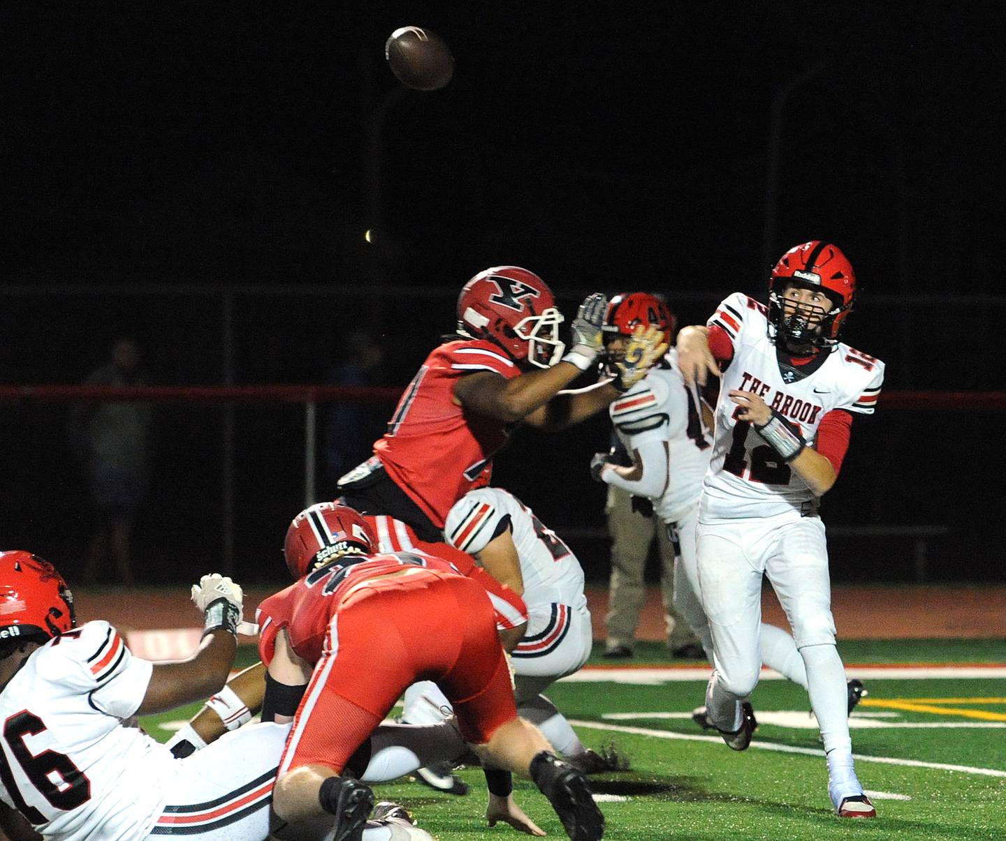 Bolingbrook quarterback Braden Anderson (12) throws a pass under pressure from a Yorkville defender on Friday, Sept. 27, 2024, during a varsity game at Yorkville High School.