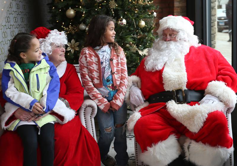 Fiona Griffin and her sister Glenda talk to Mrs. Claus and Santa at the Auditorium Ballroom during the Miracle on First Street event on Saturday, Dec. 2, 2023 in La Salle.