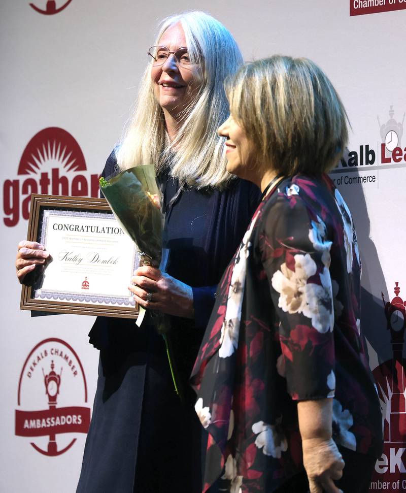 Kathy Dombek (left) smiles as she is presented with her certificate as a Woman of Accomplishment Honoree Thursday, Oct. 16, 2025, during the 35th annual Athena and Women of Accomplishment Award Reception at the Egyptian Theatre in DeKalb.
