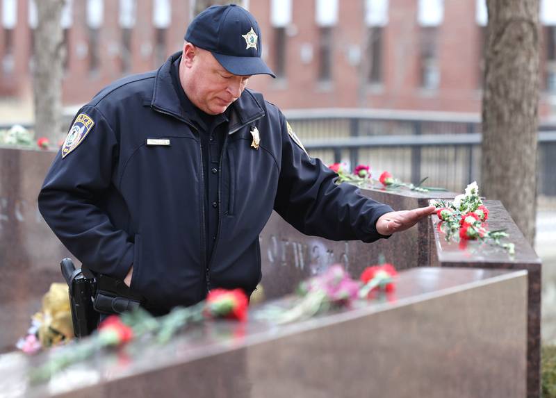 DeKalb Deputy Police Chief Jason Leverton, who was one of the officers who responded to the 2008 shootings at Northern Illinois University, pays his respects during a remembrance ceremony Tuesday, Feb. 14, 2023, at the memorial outside Cole Hall at Northern Illinois University for the victims of the mass shooting. Tuesday marked the 15th year since the deadly shooting took place on campus which took the lives of five people.