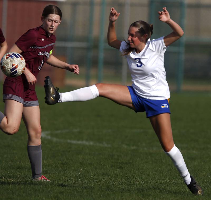 Johnsburgs Charlie Eastland (right) kicks the ball away from Marengo's Maggie Hanson during a Kishwaukee River Conference soccer match on Wednesday, April 15, 2026, at Marengo High School.