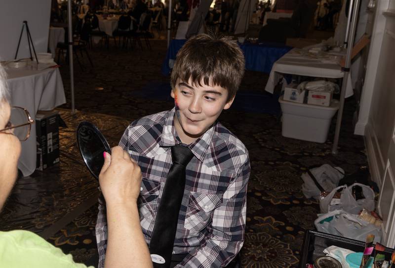 Roddick Wagner, 12, of Peru reacts to the sunset and palm trees Diane Martin of "Crazy Cat Lady Creations Face Painting" adorned his face with Sunday, April 21, 2024, at Senica's Oak Ridge in La Salle. The Chocolate Festival fundraiser benefits La Salle County Court Appointed Special Advocates.