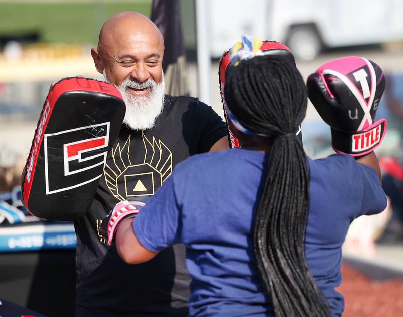 Erick Villamar, head coach at United Elite Mixed Martial Arts helps Londynn Crenshaw, 12, from DeKalb with her punching form Tuesday, Aug. 5, 2025, during National Night Out in the Hy-Vee parking lot in Sycamore.