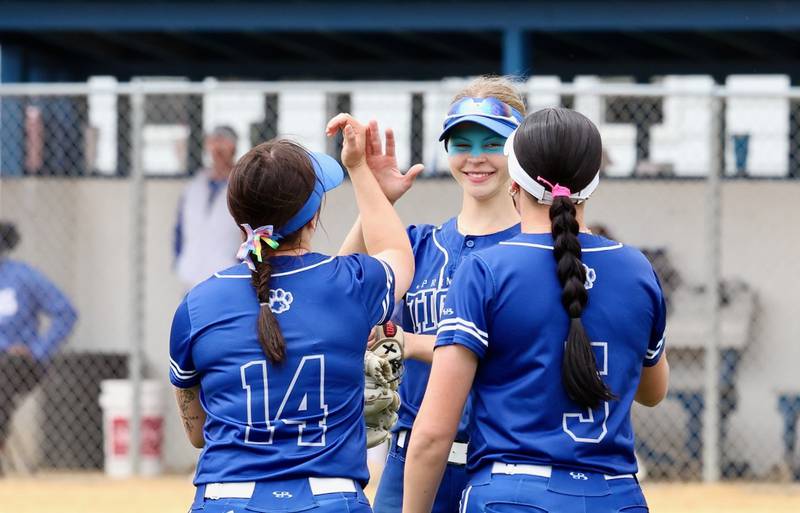Princeton's Caroline Keutzer (center) greets teammates Izzy Gibson (14) and Keely Lawson (5) during Saturday's regional championship. Morrison won 9-0.