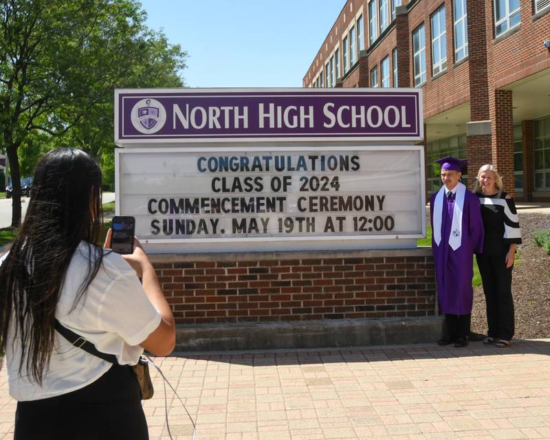 Family friend Alyssa Lopez takes a photo of Gianni Miceli and his mom Holly Frank before the start of the Downers Grove North graduation held at Downers Grove North High School on Sunday May 19, 2024.