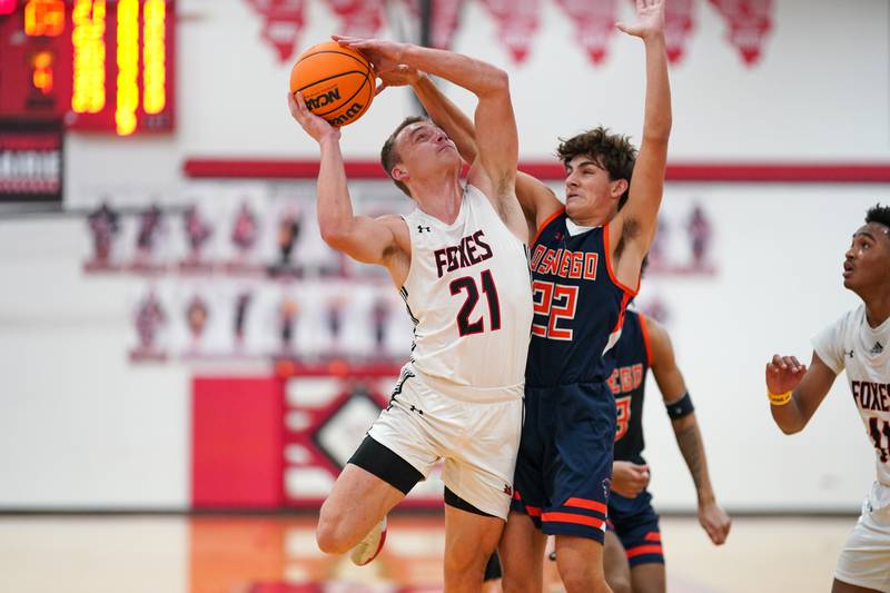 Yorkville's Taelor Clements (21) shoots the ball in the paint against Oswego’s Luke Roller (22) during a hoops for hope basketball game at Yorkville High School on Saturday, Feb. 8, 2025.