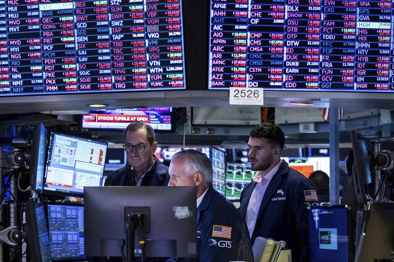 In this photo provided by the New York Stock Exchange, a trio of specialists work at a post on the floor, Monday, June 13, 2022. Fears about a possible recession are pounding markets worldwide on Monday, and Wall Street's S&P 500 tumbled into the maw of what's known as a bear market after sinking more than 20% below its record set early this year. (Courtney Crow/New York Stock Exchange via AP)