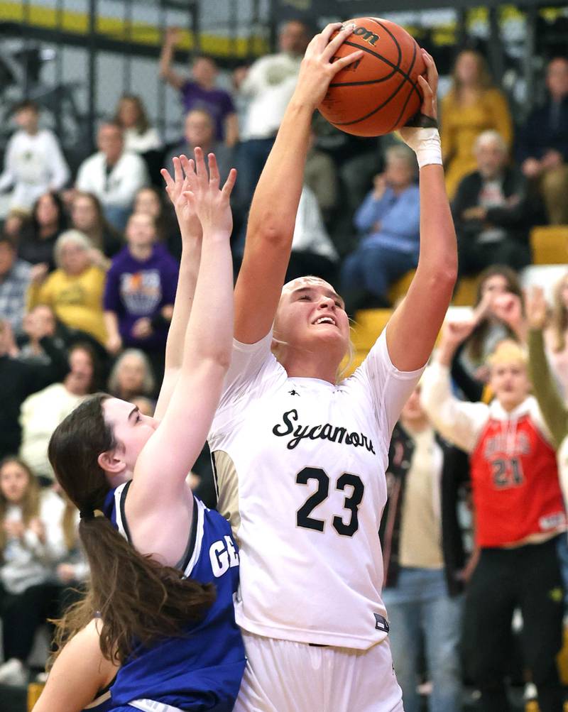 Sycamore's Evyn Carrier grabs a rebound over Geneva’s Gabby Webb during their game Monday, Nov. 14, 2022, at Sycamore High School.