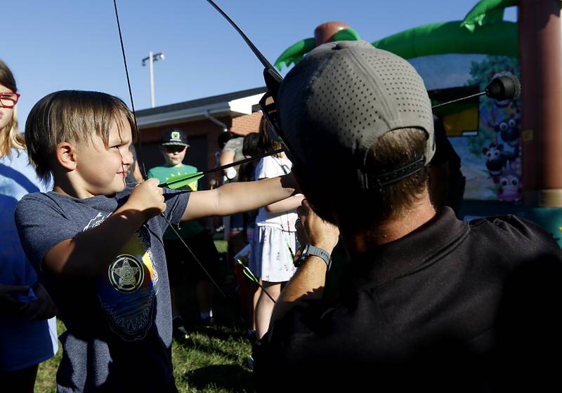McHenry County Conservation District Police officer Kyle Retek helps Zack Lishamer, 6, of Woodstock shoot an arrow during National Night Out! Tuesday, August 9, 2022, at Petersen Park in McHenry. The event was put on by the McHenry County Sheriff’s Office, City of McHenry Police Department and the McHenry County Conservation District and featured demonstrations, food and fun activities. National Night Out is held nationally in over 50,000 cities and is designed to help create relationships between neighbors and law enforcement community.