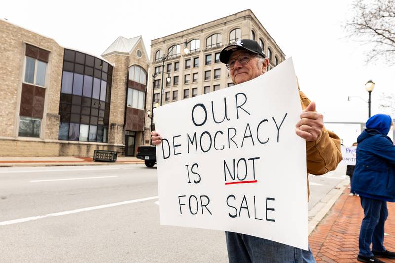 Joliet resident Bob Zimmer stands on Jefferson Street during the Hands Off protest in Downtown Joliet on April 5, 2025.