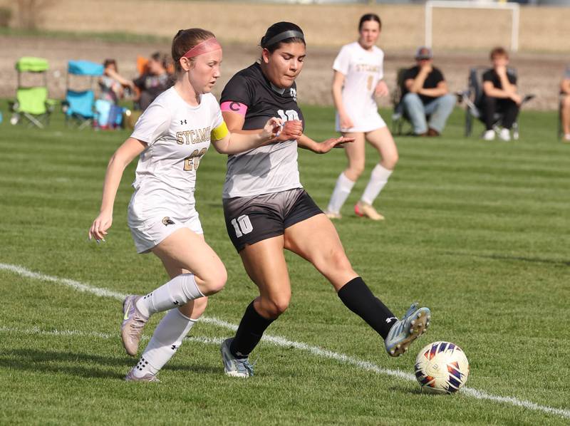 Kaneland's Adriana Warrington kicks the ball away from Sycamore's Cortni Kruizenga during their game Monday, April 13, 2026, at Kaneland High School.