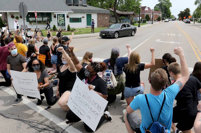 Cars are blocked by protesters in the crosswalk during a Black Lives Matter protest on Friday, June 5, 2020 in downtown Crystal Lake. More than a hundred peaceful protesters stood and chanted with signs for two hours at the 5-way stop intersection of Walkup Ave, Crystal Lake Ave, and Grant St. Every 20 minutes, the group moved into the crosswalks to block traffic for 7 minutes to raise awareness for the social injustices faced by African American people across the country. Protesters marched peacefully but vocally down Grant St and East Woodstock St to Depot Park to listen to speakers share their experiences and offer ideas to help society battle racism.