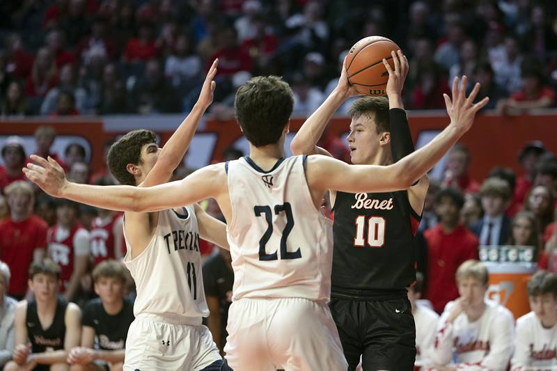 Benet Academy’s Andy Nash looks to pass while being guarded by New Trier’s Evan Kanellos and Logan Feller Friday March 10, 2023 during the 4A IHSA Boys Basketball semifinals.