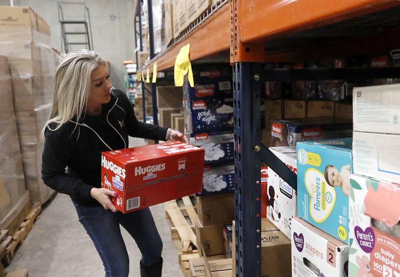 Ann Marie Mathis, the founder and CEO of Keeping Families Covered, moves diaper boxes Monday, Jan 24, 2023, inside the new facility at 4138 W. Orleans St. in McHenry. Keeping Families Covered has taken over for the Diaper Bank of Northern Illinois, one of the first National Diaper Bank Network members, which was previously at this location.
