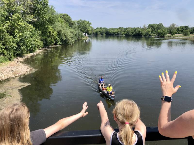 Emma and Madelyn Countryman wave to their father, Mike Countryman and his racing partner Clint Smith after waiting to see their boat from the Illinois Bridge in Aurora, just short of the finish line of the Mid-American Canoe and Kayak Race on Saturday June 3, 2023.