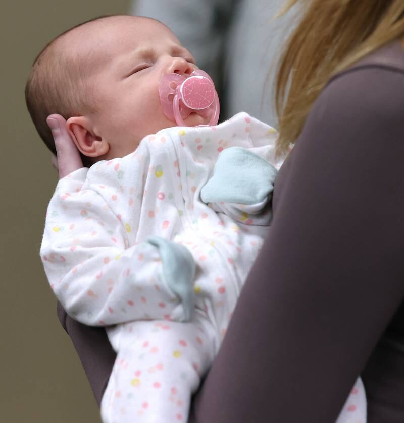 Eleanor Lee Altepeter-Knotts, from Kingston naps in her mom’s arms Thursday, Nov. 2, 2023, as she and her parents visit the Genoa-Kingston Fire Department in Genoa. The family stopped by to thank the ambulance crew that delivered the baby Sept. 29 when they realized they weren’t going to make it to the hospital in time.