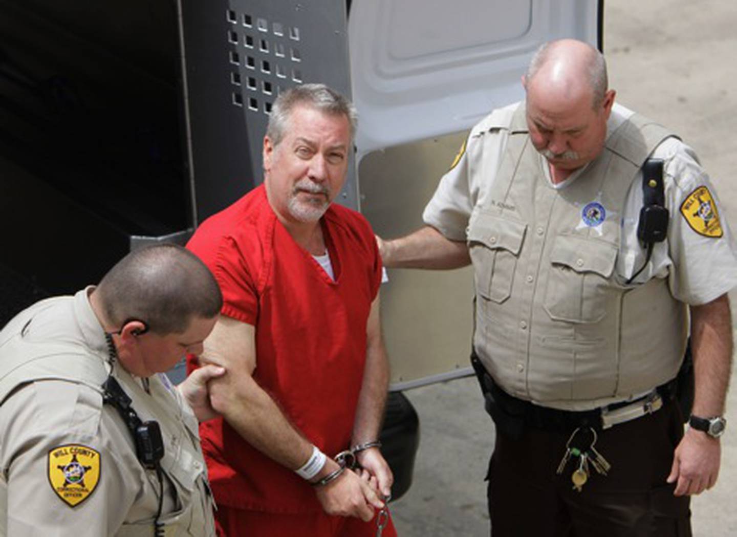 In this May 8, 2009 file photo, former Bolingbrook, Ill, police sergeant Drew Peterson, center, arrives at the Will County Courthouse in Joliet, Ill. On Monday, May 18, 2009, Peterson is scheduled to be arraigned on first-degree murder charges in the 2004 drowning death of his third wife Kathleen Savio.