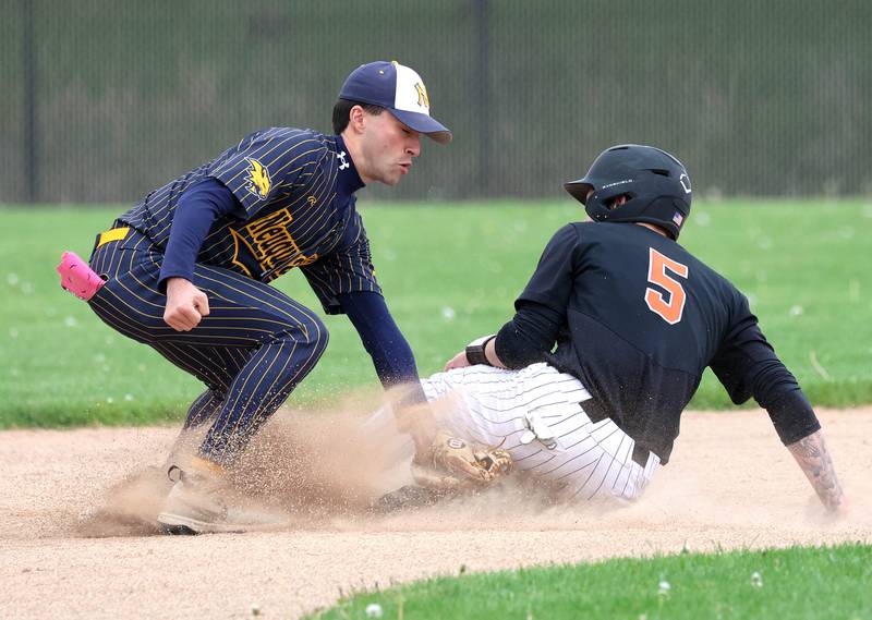 DeKalb's Cole Latimer slides in with a stolen base just ahead of the tag of Neuqua Valley's Kaeden Kraemer Tuesday, May 5, 2026, during their game at DeKalb High School.