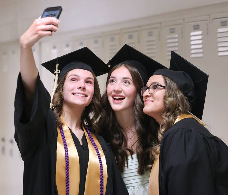 Ashlyn Smid, (left) Kathryn Hogan and Zoey Garcia (right) take a selfie before graduation Sunday, May 28, 2023, at Sycamore High School.