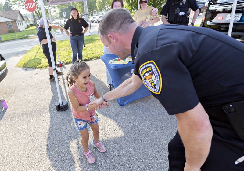 Arabella Short, 4, of Dixon excitedly shakes the hand of Dixon Chief of Police Ryan Bovines Tuesday, August 5, 2025, at National Night Out.