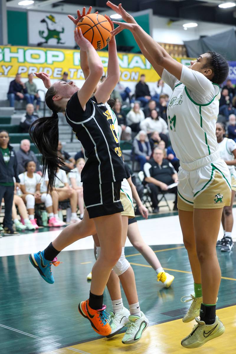 Reed-Custer's Atiana Hood shoots under pressure from Bishop McNamara's Keneyce Davis during Bishop McNamara's 60-36 victory over Reed-Custer in the IHSA Class 2A Bishop McNamara Regional semifinals on Monday, Feb. 16, 2026.