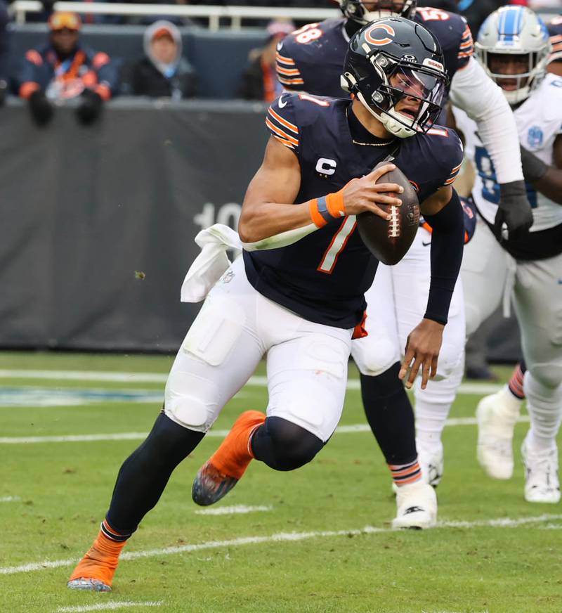 Chicago Bears quarterback Justin Fields scrambles away from the Detroit Lions pass rush during their game Sunday, Dec. 10, 2023 at Soldier Field in Chicago.