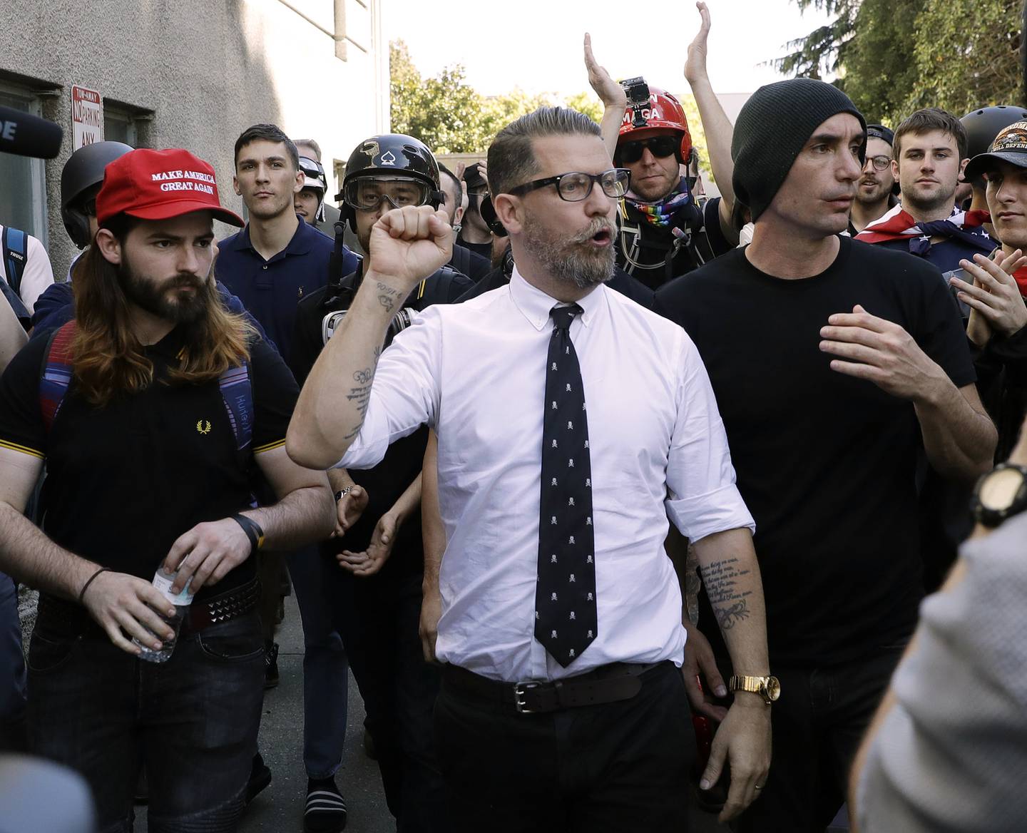 FILE - In this April 27, 2017, file photo, Gavin McInnes, center, founder of the far-right group Proud Boys, is surrounded by supporters after speaking at a rally in Berkeley, Calif. The Canadian government designated the Proud Boys group as a terrorist entity on Wednesday, Feb. 3, 2021, noting they played a pivotal role in the insurrection at the U.S. Capitol on Jan. 6. McInnes has described the group as a politically incorrect men’s club for “Western chauvinists” and denies affiliations with far-right extremist groups that overtly espouse racist and anti-Semitic views.