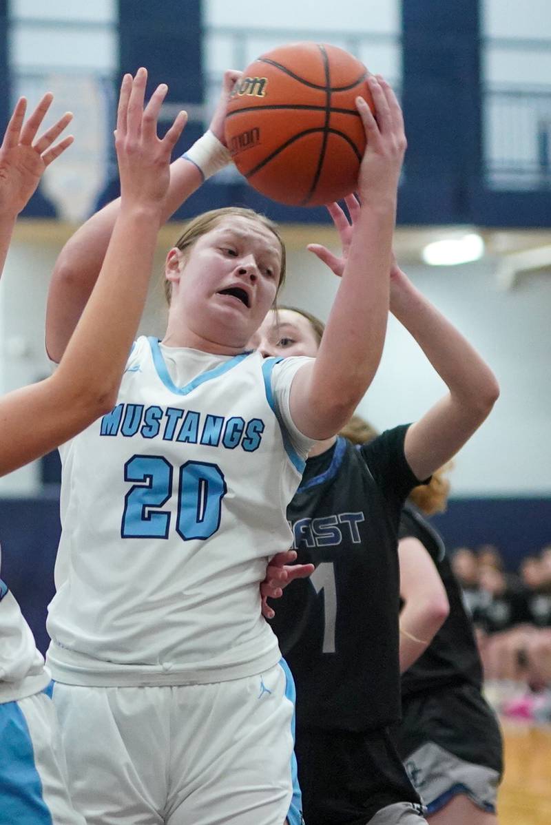 Downers Grove South's Megan Ganschow (20) rebounds the ball against Oswego East's Aubrey Lamberti (1) during a 4A Oswego East Regional semifinal girls basketball game at Oswego East High School on Monday, Feb 12, 2024.