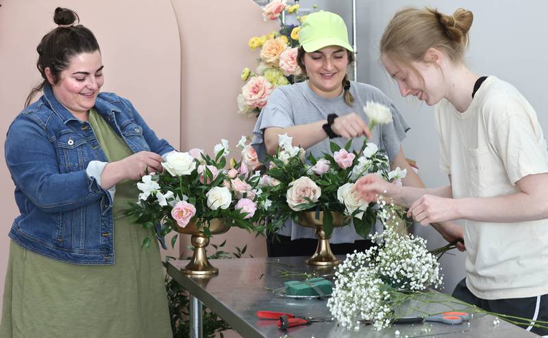 Willrett Flower Company Owners Mary Grace McCauley (left) and her sister Kat Willrett along with design assistant Lauren Hopkins (right) build some arrangements Friday, May 13, 2022, in the store at 302 E. Lincoln Highway in DeKalb. The location will soon be filled with flowers and gift items as they get ready for the opening in June.