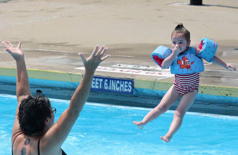 CJ Summer, 4, from Cortland jumps to her grandma Tuesday, July 25, 2023, at Hopkins Pool in DeKalb.