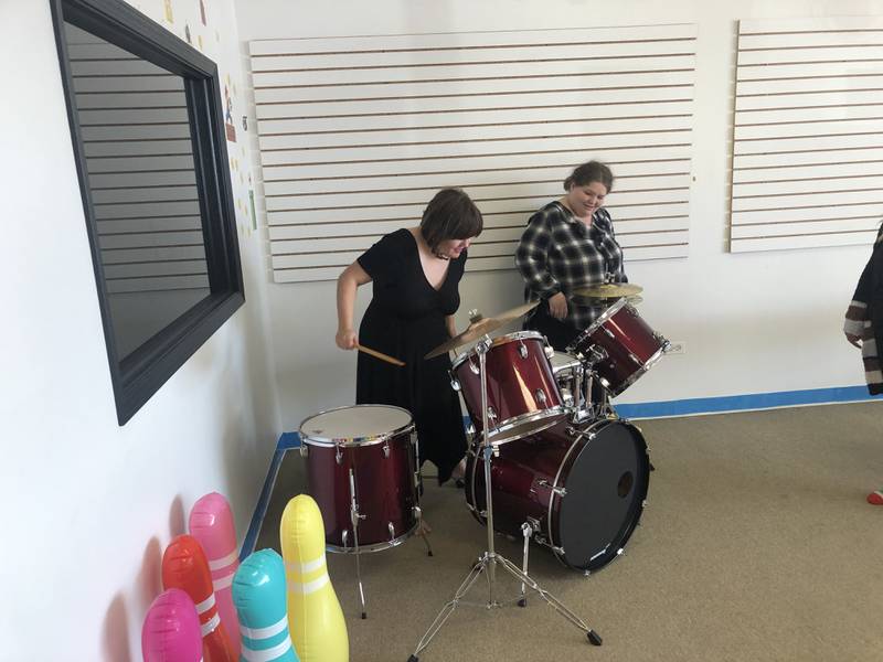 Barbra Lynn, right, plays on the drum set with sister Lizzy Lynn looking on at Spring Grove-based Rockin' the Spectrum on Wednesday, Nov. 1, 2023. The clubhouse-based program offers respite care for autistic clients.
