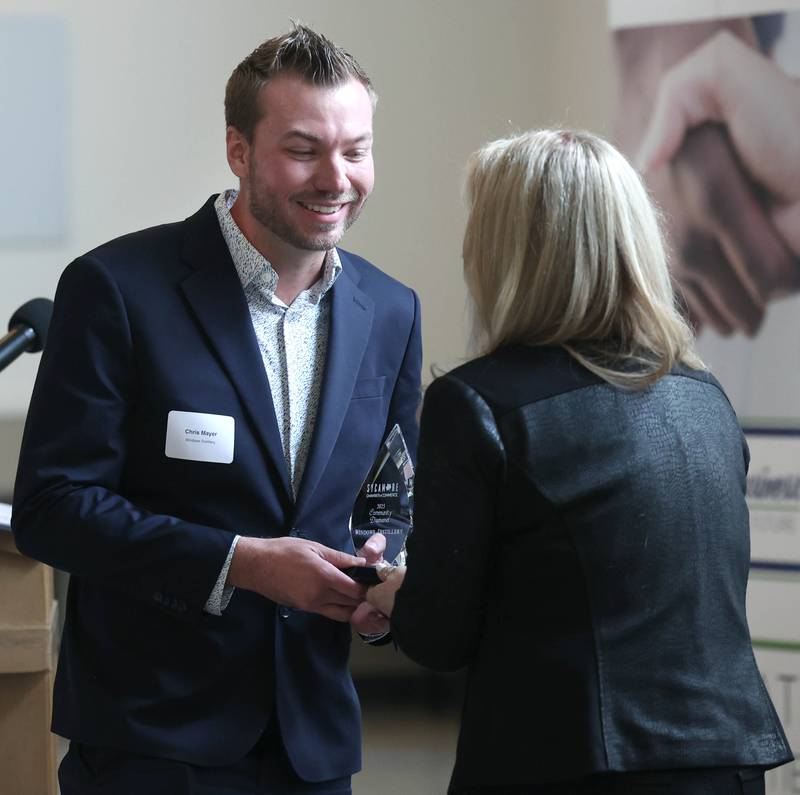Chris Mayer, (left) founder and owner of Windows Distillery, is presented with the Community Diamond Award Thursday, March 5, 2026, during the Sycamore Chamber of Commerce Annual Meeting in Memorial Hall at St. Mary's Catholic Church in Sycamore.