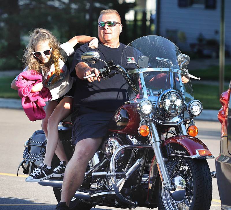 Lily Lippold arrives in style for her first day of fourth grade on the back of her dad Neal's motorcycle Tuesday, Aug. 16, 2022, on opening day at Genoa Elementary School.