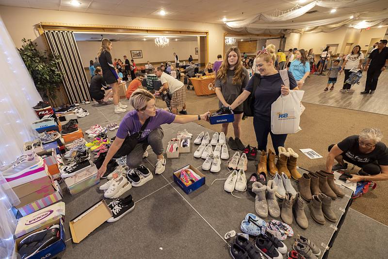 Sara Faley hands out shoes Thursday, Aug. 8, 2024 at the the Elks Lodge in Dixon. Faley saw a need for shoes for local school children so she organized the drive that teamed up nicely with the Tools for Schools distribution day.