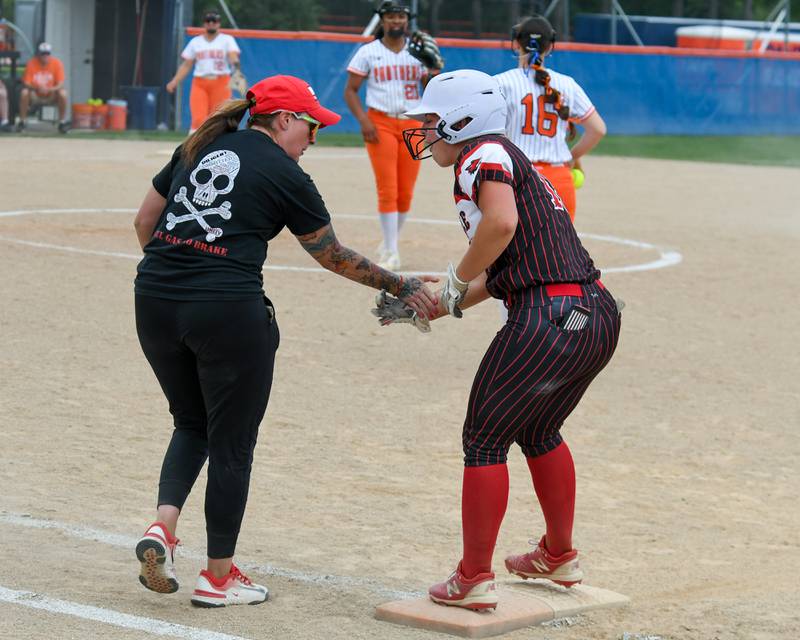 Yorkville's Ellie Fox (13) gets congratulated by her coach after getting a base hit during the sectional semifinal game on Tuesday June 3, 2025, while they travel to take on Oswego High School.