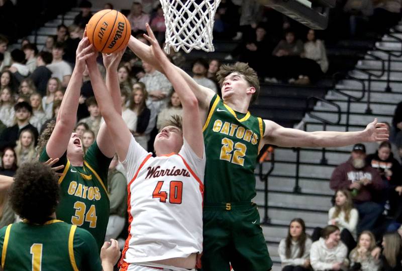 McHenry’s Nathan Ottaway, center, battles Crystal Lake South’s Johnathan Morgan, left, and Nick Stowasser, right, for the ball in varsity boys basketball on Friday, Feb. 20, 2026, at McHenry High School in McHenry.